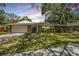 Charming home featuring stone accents, a well-manicured lawn and beautiful trees at 34 Hickory Ln, Safety Harbor, FL 34695