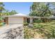 Charming home featuring stone accents, a well-manicured lawn and beautiful trees at 34 Hickory Ln, Safety Harbor, FL 34695