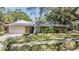 Charming home featuring stone accents, a well-manicured lawn and beautiful trees at 34 Hickory Ln, Safety Harbor, FL 34695