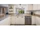 Bright kitchen with stainless steel dishwasher and sleek white cabinetry offers modern appeal at 34 Hickory Ln, Safety Harbor, FL 34695