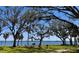 Scenic view of a serene park with picnic benches, shady trees, and a glimpse of the water at 34 Hickory Ln, Safety Harbor, FL 34695