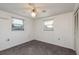 A well-lit bedroom with white walls has two windows and a ceiling fan at 3706 Cambridge St, New Port Richey, FL 34652