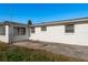 Exterior view shows a home's side with white siding, multiple windows, a concrete patio, and landscaping at 3706 Cambridge St, New Port Richey, FL 34652