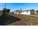 A spacious backyard featuring a well-maintained lawn and a charming white home with a classic design at 3706 Cambridge St, New Port Richey, FL 34652