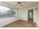 Bright living room with natural light, ceiling fan, beige carpet, and an open doorway to another room with green walls at 3706 Cambridge St, New Port Richey, FL 34652