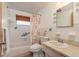Cozy bathroom featuring tiled walls, a shower-tub combo, and a neutral vanity, providing comfort and functionality at 3706 Cambridge St, New Port Richey, FL 34652