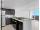 A kitchen featuring granite countertops, black cabinets, and stainless steel appliances at 4015 Bayshore Blvd # 8E, Tampa, FL 33611