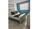 Stylish bedroom with a gray bed dressed in green and orange pillows, featuring a teal accent wall and modern design at 4644 Bay Crest Dr, Tampa, FL 33615