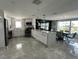 Modern kitchen with sleek white cabinetry, quartz countertops, stainless steel appliances, and open-concept dining area at 4644 Bay Crest Dr, Tampa, FL 33615