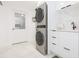 Bright laundry room featuring stacked washer/dryer and modern white cabinets with marble countertops at 4644 Bay Crest Dr, Tampa, FL 33615