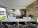 Outdoor kitchen with marble island, stainless steel grill, and bar seating in a covered patio at 4644 Bay Crest Dr, Tampa, FL 33615