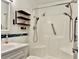 Updated bathroom featuring walk-in shower, grab bar, dual shower heads, and floating shelves at 5501 80Th N St # 509, St Petersburg, FL 33709