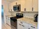 Modern kitchen featuring stainless steel appliances, granite counters, and sleek white cabinetry at 5501 80Th N St # 509, St Petersburg, FL 33709