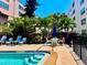 Community pool deck with multiple seating areas, palm trees, and tropical plantings for a relaxing atmosphere at 5501 80Th N St # 509, St Petersburg, FL 33709