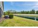 Backyard view featuring a well-maintained lawn and scenic pond at 5710 Grand Sonata Ave, Lutz, FL 33558