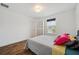 Bright bedroom with wood floors and a gray bed in front of the window at 5710 Grand Sonata Ave, Lutz, FL 33558