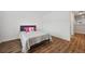 Bright bedroom with wood floors and a gray bed in front of the window at 5710 Grand Sonata Ave, Lutz, FL 33558