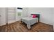 Bright bedroom with wood floors and a gray bed in front of the window at 5710 Grand Sonata Ave, Lutz, FL 33558