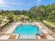 Aerial view of the community pool with sun loungers, umbrellas and plenty of space for residents to relax and enjoy the pool at 5710 Grand Sonata Ave, Lutz, FL 33558