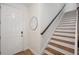 Welcoming entryway featuring a staircase, mirror, and a front door, creating a charming first impression at 5710 Grand Sonata Ave, Lutz, FL 33558
