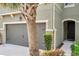 A close up of the townhome showcasing the two car garage and the front entrance with landscaping at 5710 Grand Sonata Ave, Lutz, FL 33558