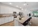 Modern kitchen boasts white cabinetry, stainless steel appliances, and a spacious island with seating at 5710 Grand Sonata Ave, Lutz, FL 33558