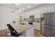 Bright kitchen featuring white cabinets, stainless steel appliances, a speckled countertop and a breakfast bar at 5710 Grand Sonata Ave, Lutz, FL 33558