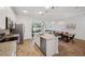 Stylish kitchen with stainless appliances, a central island, and an open layout to living and dining areas at 5710 Grand Sonata Ave, Lutz, FL 33558