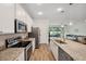 Bright, open kitchen featuring stainless steel appliances, granite countertops, and access to the living area at 5710 Grand Sonata Ave, Lutz, FL 33558