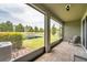 Screened-in lanai with brick flooring overlooking the serene pond at 5710 Grand Sonata Ave, Lutz, FL 33558