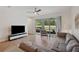 Cozy living room featuring tile flooring, a comfortable sofa, and sliding glass doors that open to the backyard at 5710 Grand Sonata Ave, Lutz, FL 33558