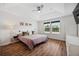 Bright main bedroom with tray ceilings, ceiling fan, hardwood floors, and dual windows at 5710 Grand Sonata Ave, Lutz, FL 33558