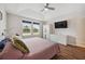 Bright main bedroom featuring a ceiling fan, hardwood floors, and plentiful natural light at 5710 Grand Sonata Ave, Lutz, FL 33558