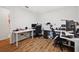 Home office has multiple workstations, wood floors, and lots of natural light at 5710 Grand Sonata Ave, Lutz, FL 33558