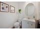 Charming powder room featuring white fixtures, neutral colors, and decorative art at 5710 Grand Sonata Ave, Lutz, FL 33558
