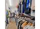 This walk-in closet has wood floors and rods and shelves for holding clothing and shoes at 5710 Grand Sonata Ave, Lutz, FL 33558