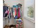 Walk-in closet has clothes hanging on racks and shelving units holding shoes at 5710 Grand Sonata Ave, Lutz, FL 33558