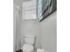 Bright bathroom features a toilet, window with blinds, and modern wall art at 6203 34Th E Ct, Ellenton, FL 34222