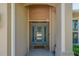 View of the front door with glass panels framed by beige stucco walls at 6203 34Th E Ct, Ellenton, FL 34222