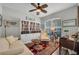 Comfortable living room area with a large bookshelf, ceiling fan, and an abundance of natural light at 6203 34Th E Ct, Ellenton, FL 34222