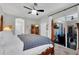Inviting main bedroom featuring a four-poster bed, a ceiling fan, and outdoor access to a covered patio at 6203 34Th E Ct, Ellenton, FL 34222
