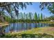 Scenic view of the backyard pond with mature trees at 6203 34Th E Ct, Ellenton, FL 34222