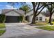 Inviting single-story home with a well-maintained lawn, mature trees, and a two-car garage at 6501 Appaloosa Dr, Tampa, FL 33625