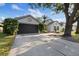 Inviting single-story home with a well-maintained lawn, mature trees, and a two-car garage at 6501 Appaloosa Dr, Tampa, FL 33625