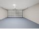 A spacious two car garage featuring an automatic garage door and painted floor at 6501 Appaloosa Dr, Tampa, FL 33625