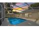 View of the in-ground pool with a screened enclosure and sunset sky at 6501 Appaloosa Dr, Tampa, FL 33625