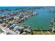 Wide aerial of waterfront neighborhood with homes, docks, and boats on a sunny day at 712 Sunset Cv, Madeira Beach, FL 33708