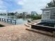 Waterfront backyard showcasing a brick patio with a luxurious built-in hot tub and serene water views at 712 Sunset Cv, Madeira Beach, FL 33708