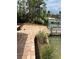 This brick backyard area features a waterfront view and lush greenery for an outdoor living experience at 712 Sunset Cv, Madeira Beach, FL 33708