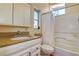 Cozy bathroom featuring a granite countertop, white cabinetry, and shower-tub combination at 712 Sunset Cv, Madeira Beach, FL 33708